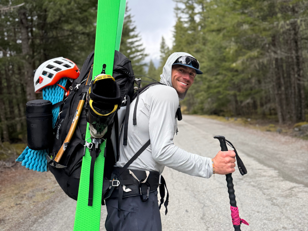 Smiling skier carrying a very heavy pack on the Garibaldi Neve Traverse