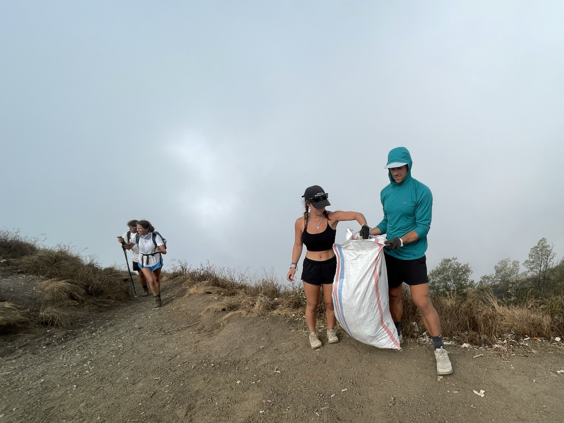 Hiker picking up trash on trail
