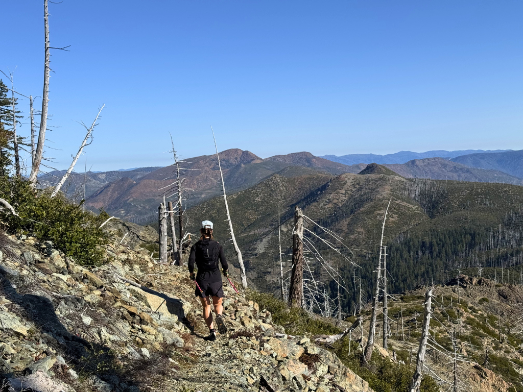 Hiker jogging downhill on a mountain trail