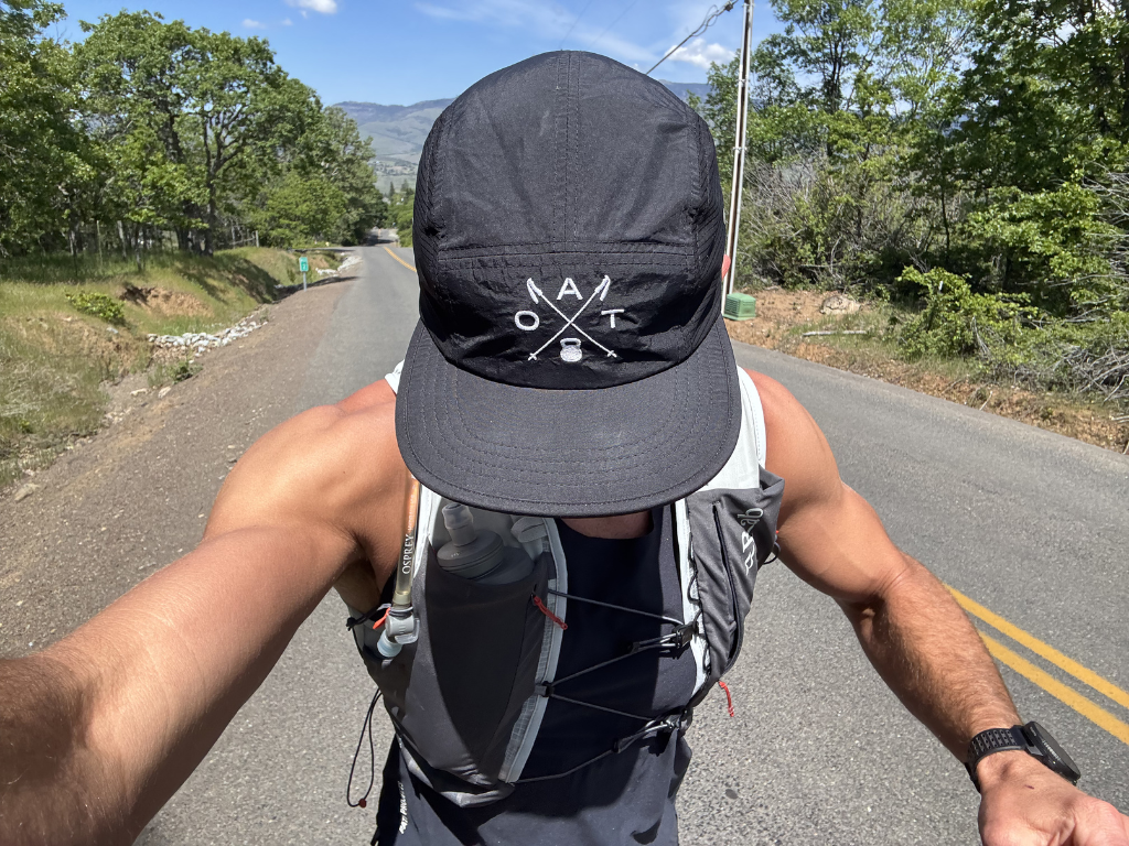 Hiker running uphill in an OAT hat