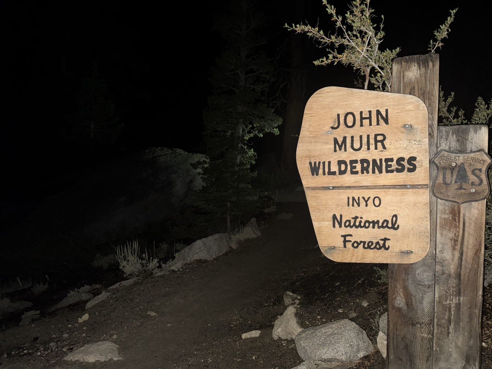 Trail sign lit by headlamp during a pre-dawn alpine start in the Eastern Sierra