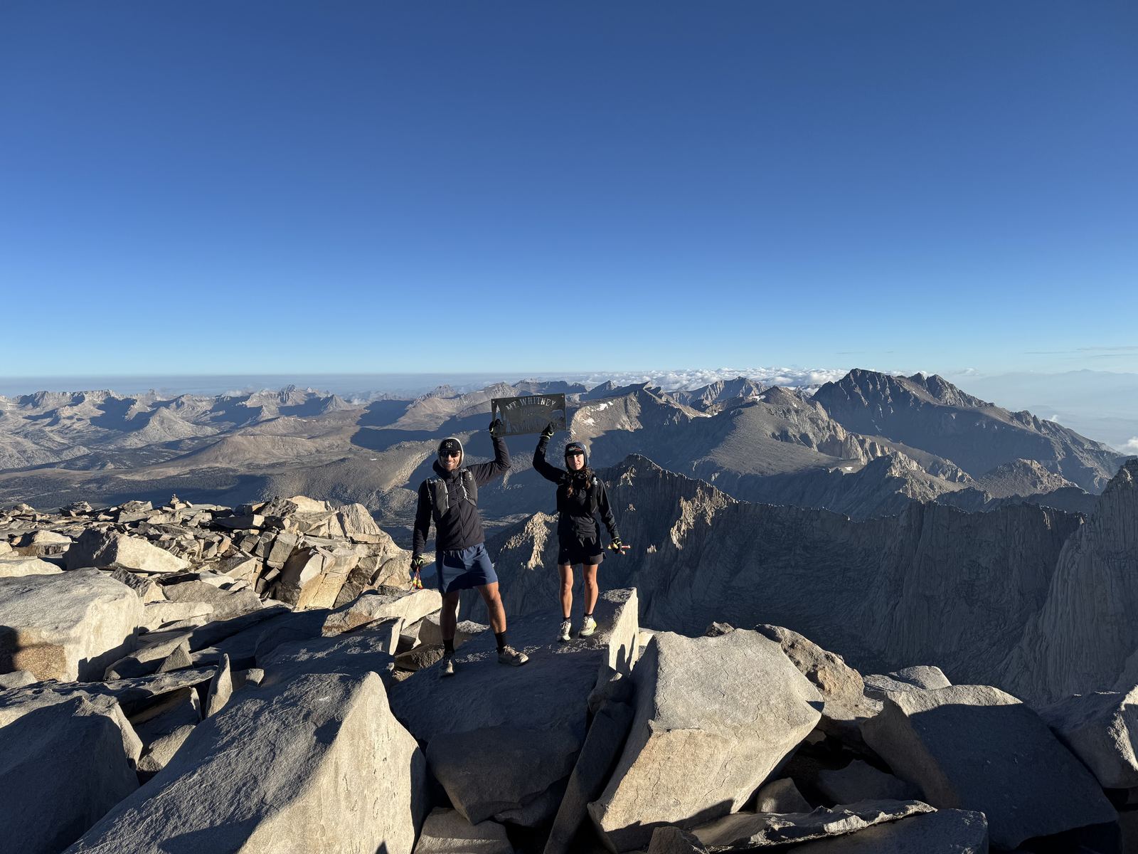 Two hikers on the summit of Mount Whitney at 14,505 feet