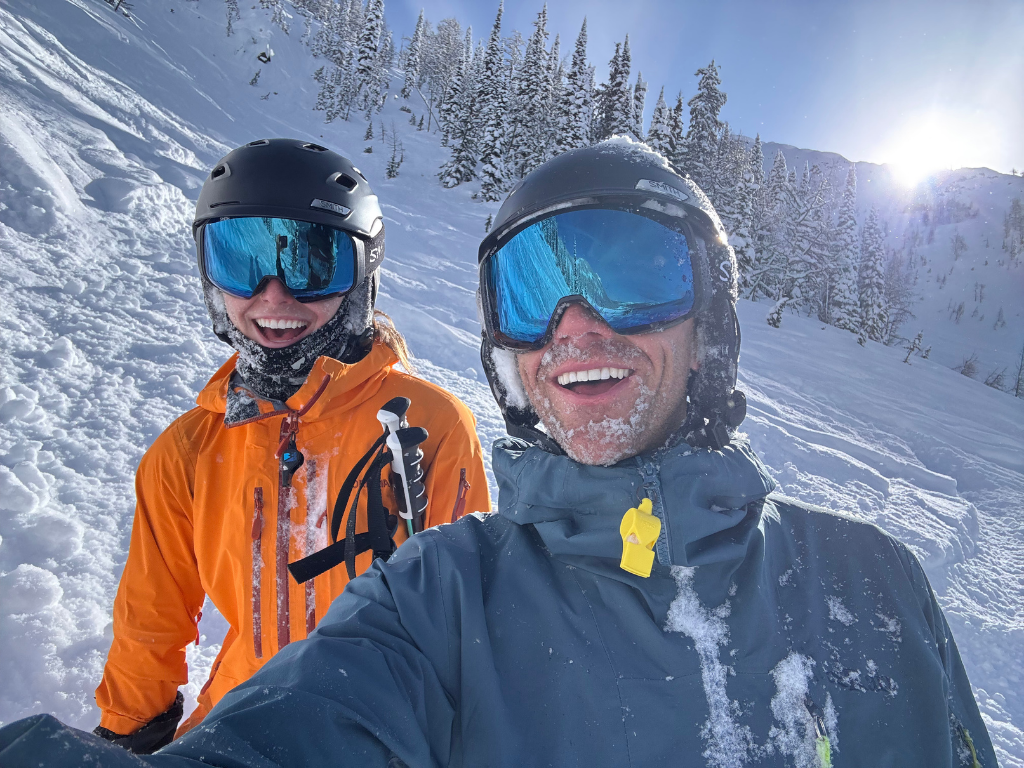 Mikey and Emily Bell covered in snow after a powder run