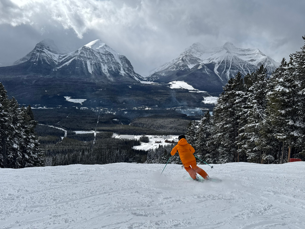 Skier carving a groomer at Lake Louise with high edge angle