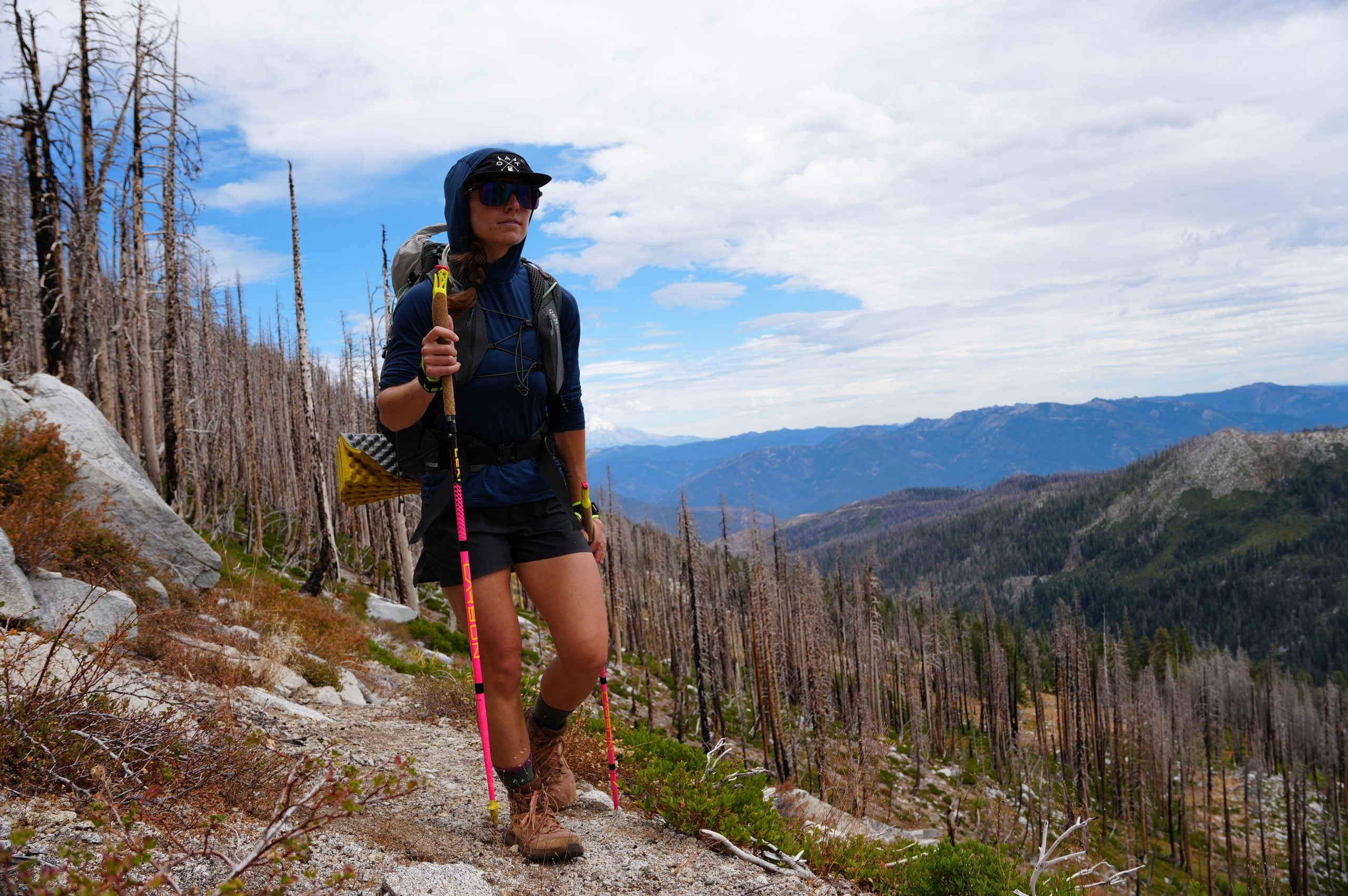 Hiker choking up on a trekking pole grip on a steep climb