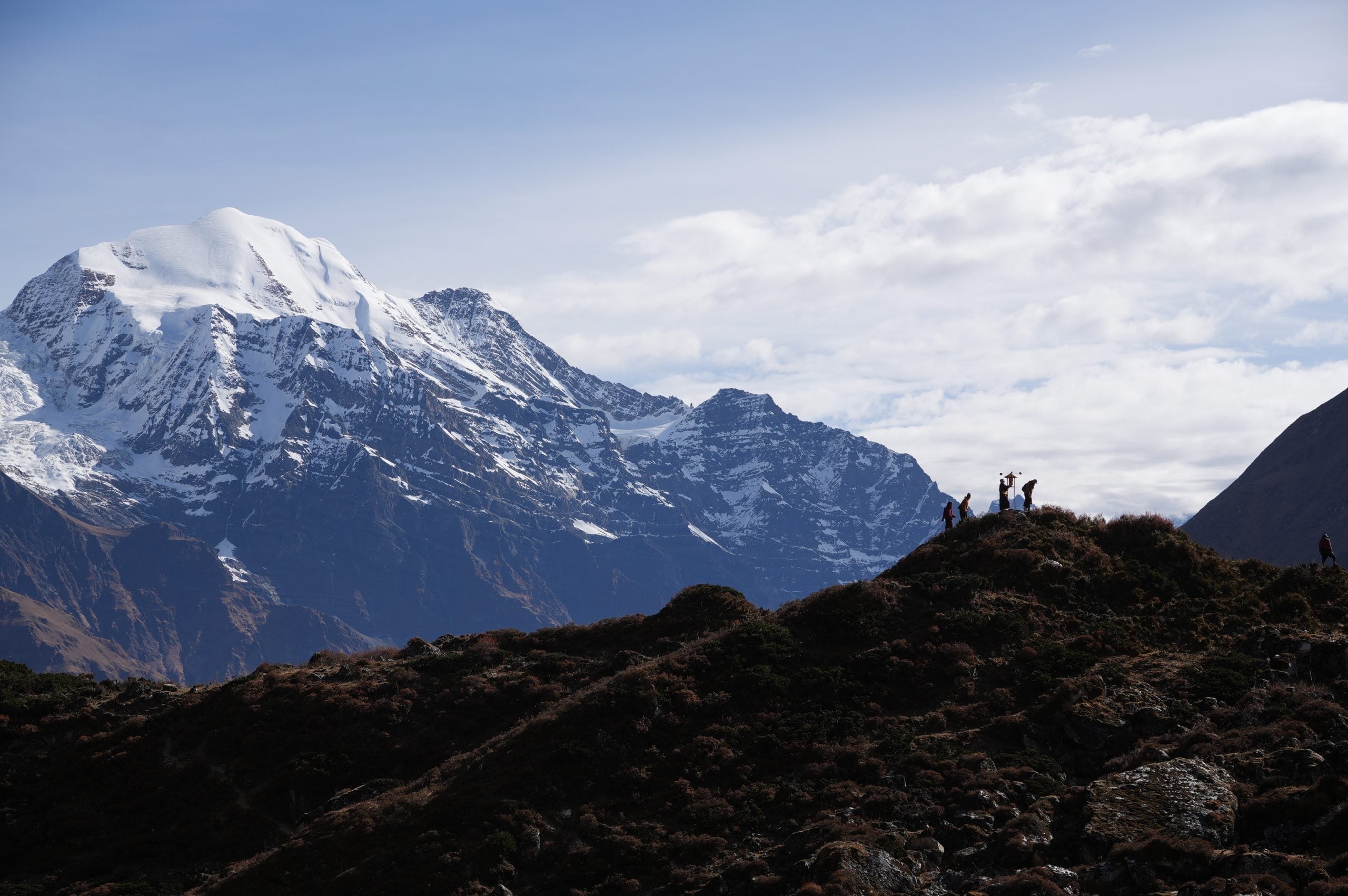 Four monks hiking along a ridge near Pungyen Gompa