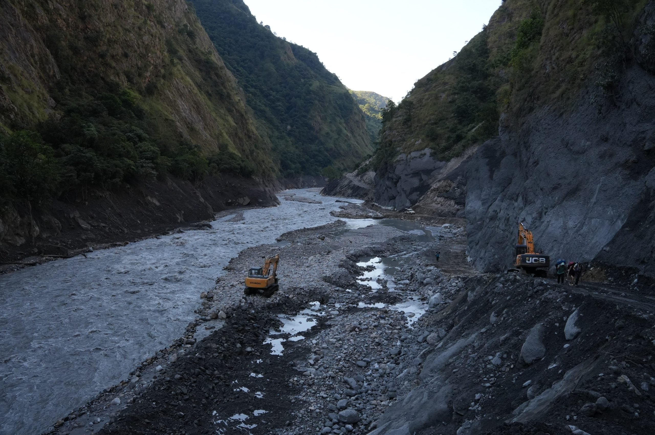 An excavator rebuilding the road in the Budhi Gandaki flood zone